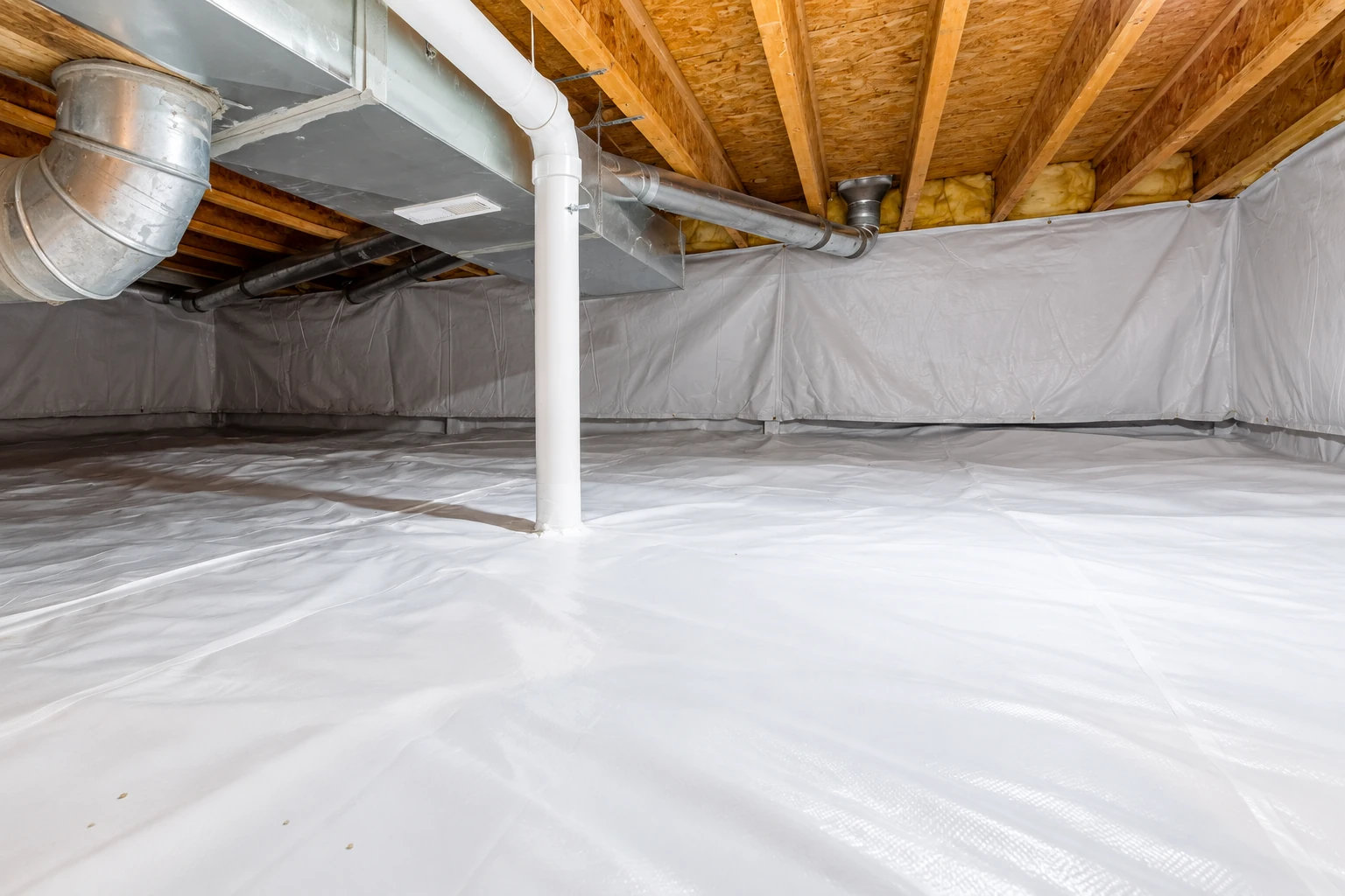 Crawl space with white vapor-barrier sheeting covering the floor and walls beneath exposed joists and ductwork.